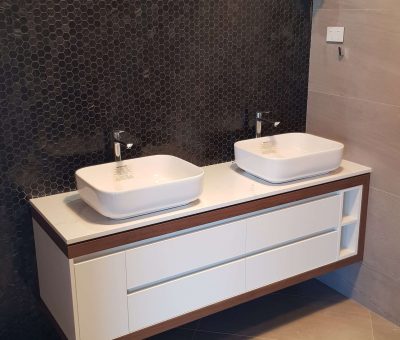 Floating double vanity with two square basins and dark textured tile backsplash.