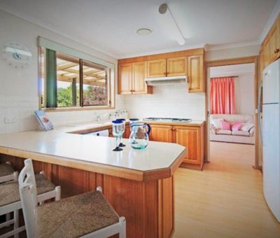 “Warm classic kitchen with timber cabinetry and a cozy breakfast bar.”