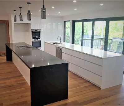 “Contemporary kitchen with contrasting dual islands and sleek black-and-white finishes.”