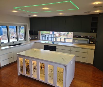 “Flynn kitchen after renovation, showcasing a sleek marble island with display cabinetry and contemporary finishes.”