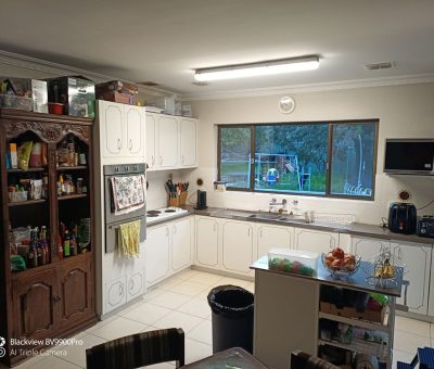 “Flynn kitchen before renovation, showing dated cabinetry and cluttered storage.”