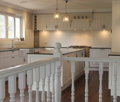 “Elegant white kitchen with timeless shaker-style cabinetry and warm timber flooring.”