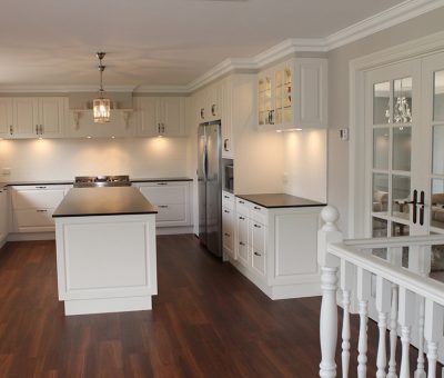 “Traditional white kitchen with a central island and elegant finishes.”