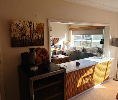 “Queanbeyan kitchen before renovation, showing dated wood finishes and compact layout.”
