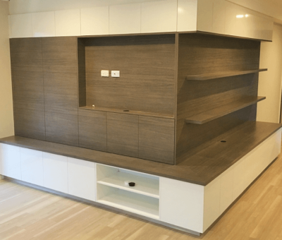 Modern living room wall unit with a sleek design. Features light wood paneling, white cabinetry, and open shelves. Calm, minimalist aesthetic.