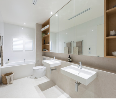 “Bright modern bathroom with double sinks, built-in shelving, and bathtub.”