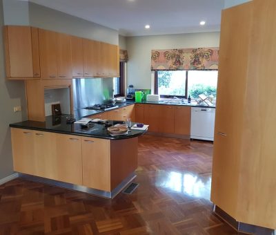 “Traditional kitchen with timber cabinetry and dark benchtops before renovation.”