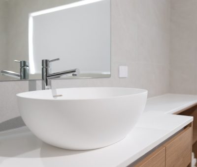 “Close-up of modern bathroom vanity with round white basin and chrome tap.”