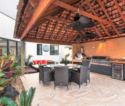 “Resort-style alfresco kitchen with built-in BBQ, dining area, and lounge under a pitched tiled roof.”