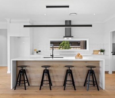 “Bright contemporary kitchen with a wood-accent island and sleek black details.”
